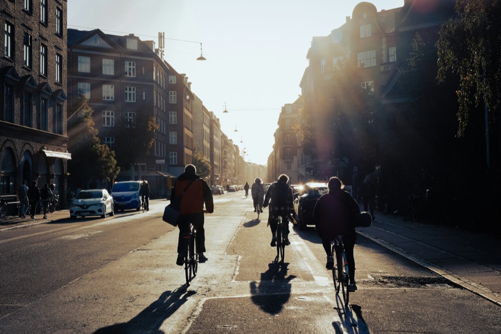 Cyclists riding into the sunset on a city street
