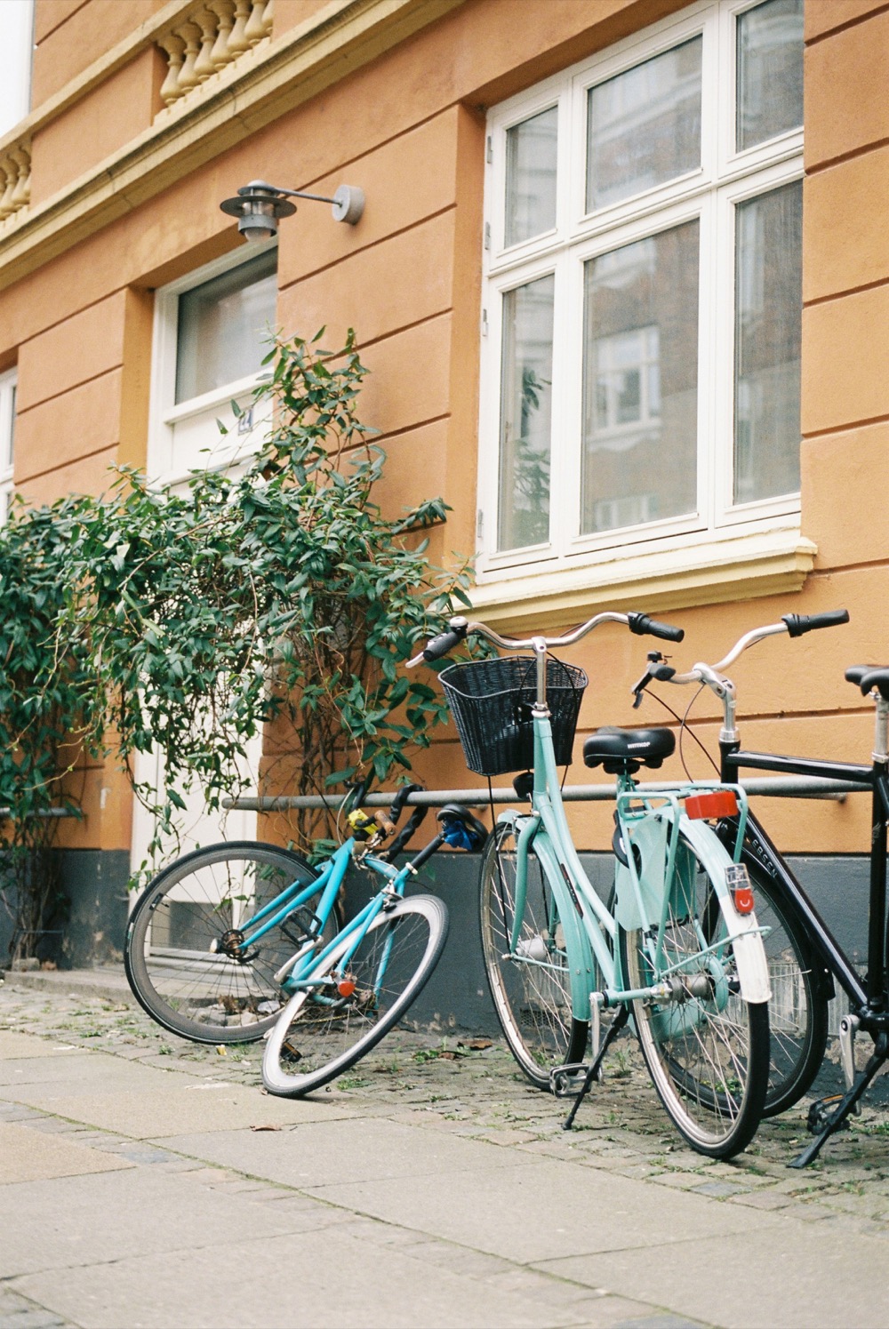 Bikes leaning against an orange building wall