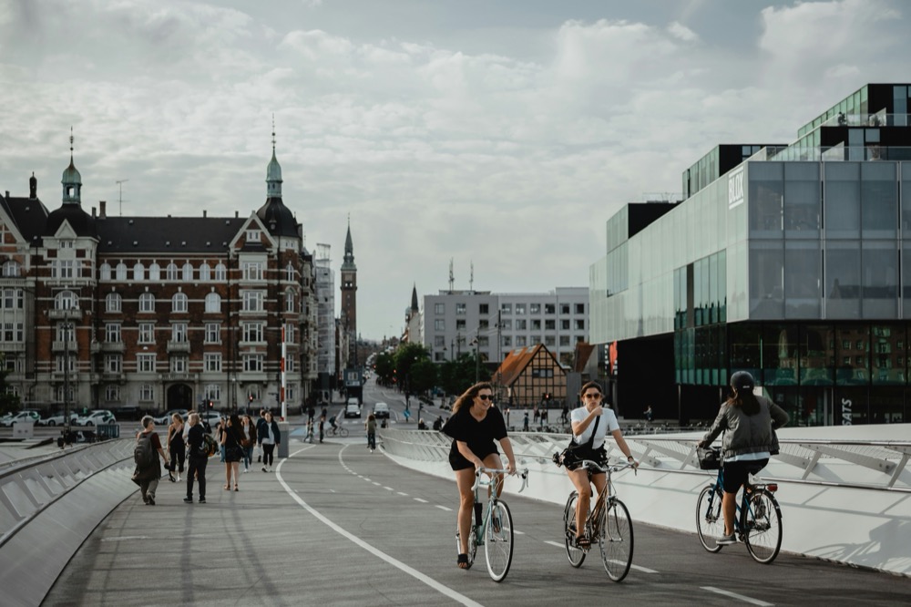 Riders crossing a bike bridge by the BLOX building